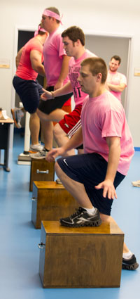 LECOM Students in pink shirts on step blocks