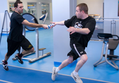 LECOM students racing passing baton in race on indoor track 