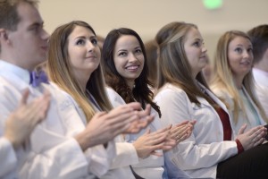 Close up view of students clapping in LECOM Erie's white coat ceremony.
