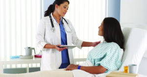 Female Doctor checking on female patient in recovery room