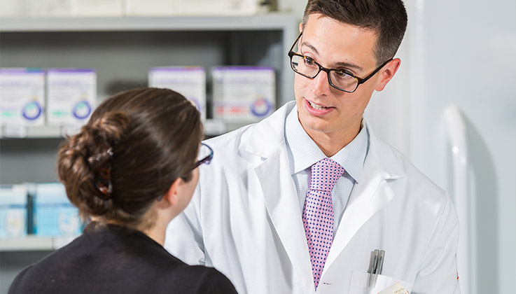 Pharmacist with patient at pharmacy image by LECOM