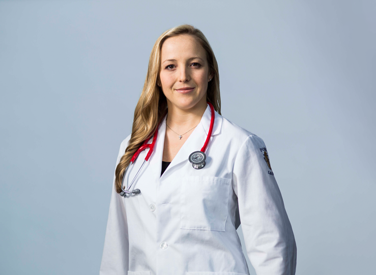 Female student in white coat with pink stethoscope at LECOM