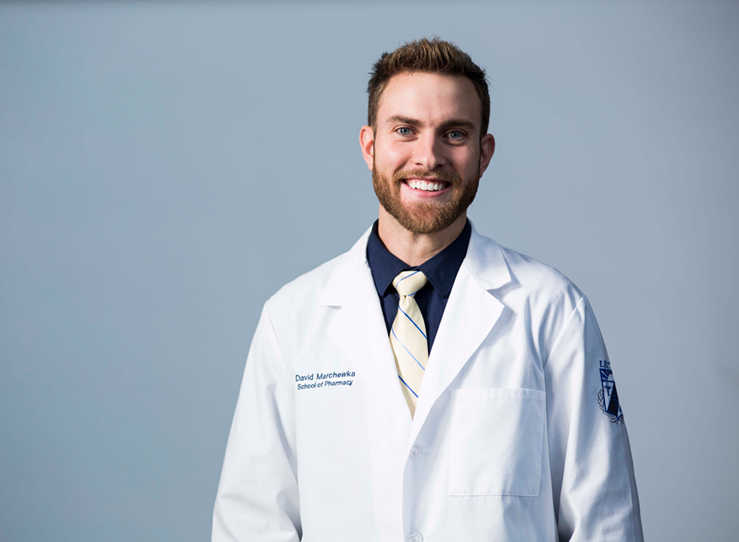 Young male student in white coat and tie at LECOM