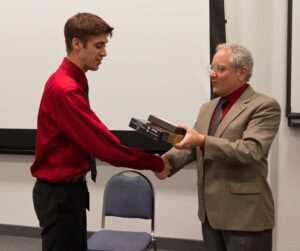 Professor presenting first stethscope to student in class.