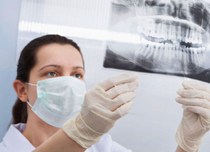 Doctor in mask looking at dental xray