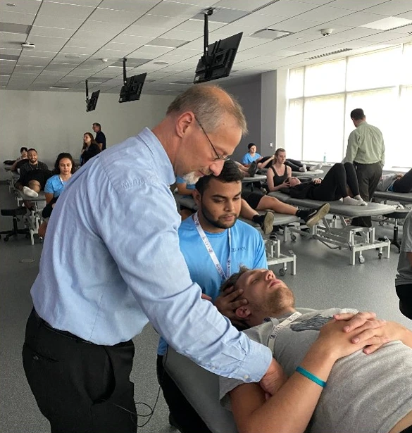 Instructor demonstrates osteopathic hands-on technique on a student in a clinical skills lab